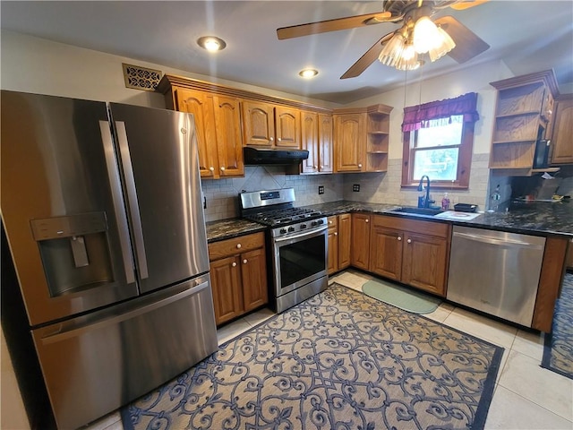 kitchen featuring ceiling fan, sink, stainless steel appliances, range hood, and decorative backsplash