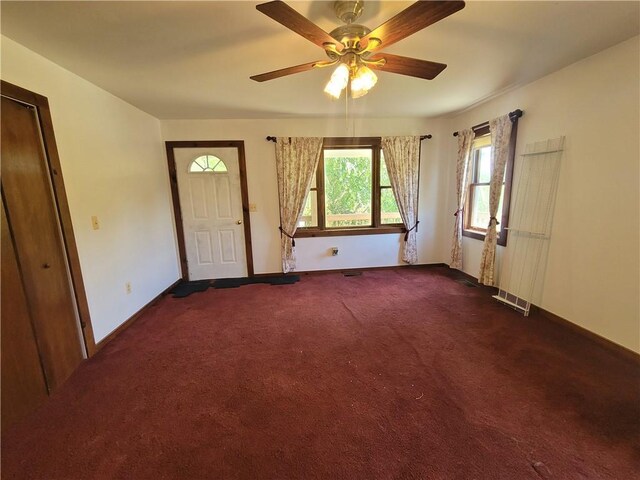 entryway featuring dark colored carpet and ceiling fan