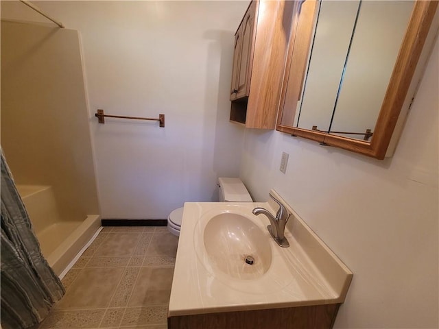 bathroom with vanity, curtained shower, and toilet