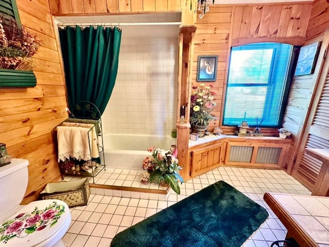 bathroom with tile patterned floors, wood walls, toilet, and a tub