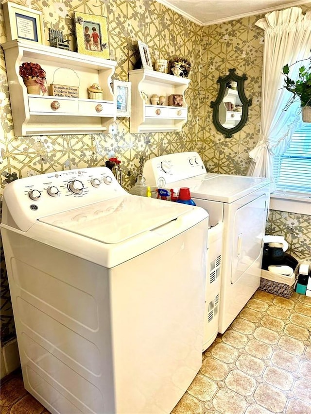 clothes washing area featuring crown molding and washer and clothes dryer