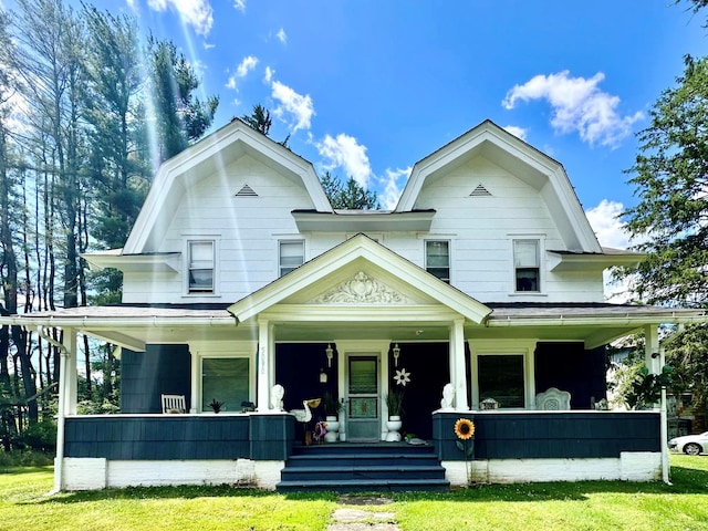 dutch colonial featuring a porch, a gambrel roof, and a front lawn