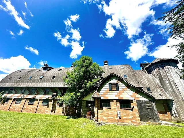 rear view of property featuring a yard