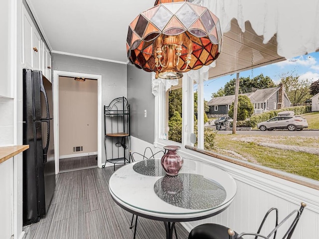 dining room featuring crown molding, hardwood / wood-style flooring, and a notable chandelier