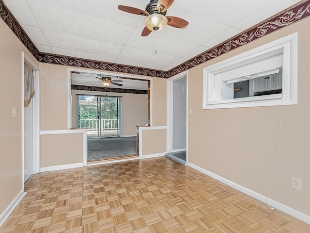 spare room with light parquet floors and a drop ceiling