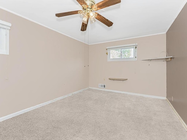 empty room featuring carpet, ceiling fan, and crown molding