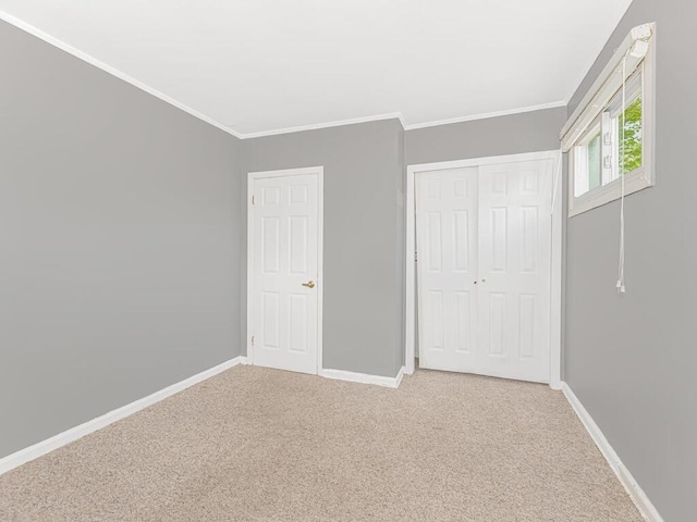 unfurnished bedroom with carpet flooring, a closet, and crown molding