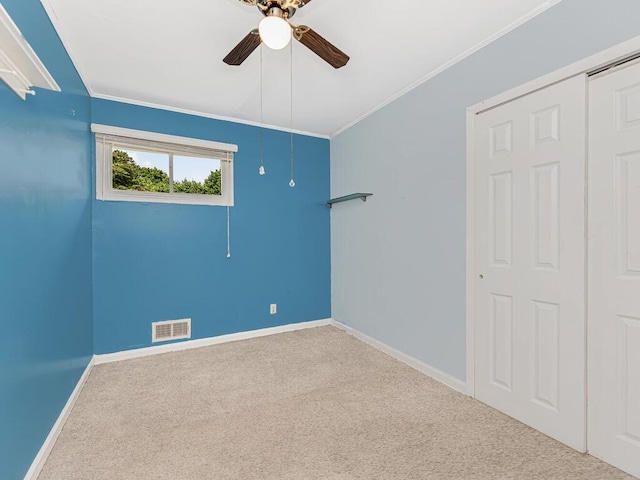 unfurnished room with carpet flooring, ceiling fan, and ornamental molding