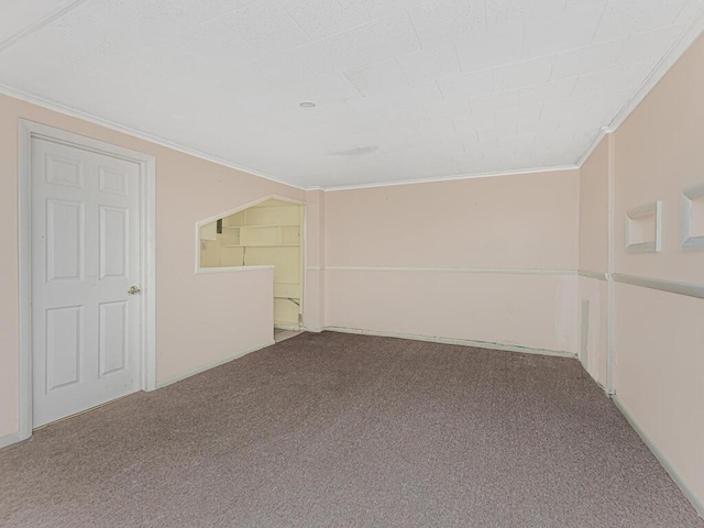 carpeted empty room featuring crown molding