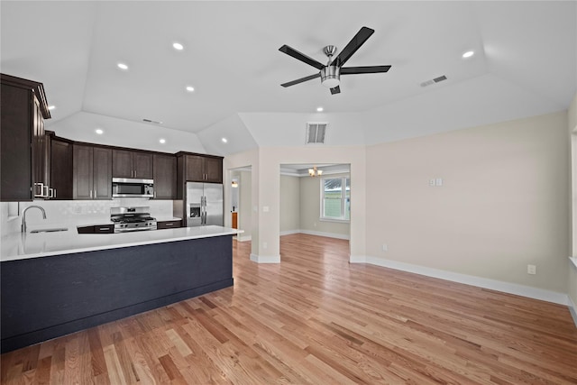 kitchen featuring lofted ceiling, sink, ceiling fan, appliances with stainless steel finishes, and light hardwood / wood-style floors