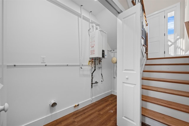 clothes washing area with water heater, dark hardwood / wood-style flooring, and hookup for a gas dryer