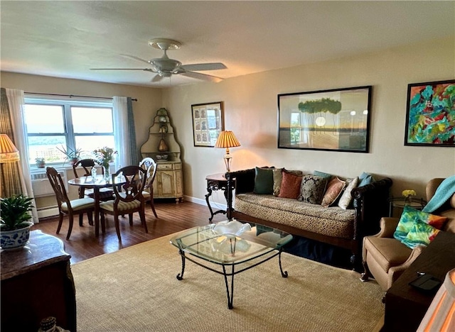 living room with dark hardwood / wood-style flooring and ceiling fan