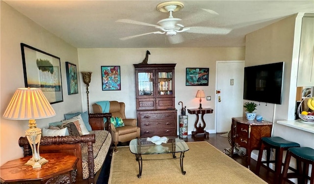 living room with ceiling fan and dark hardwood / wood-style flooring