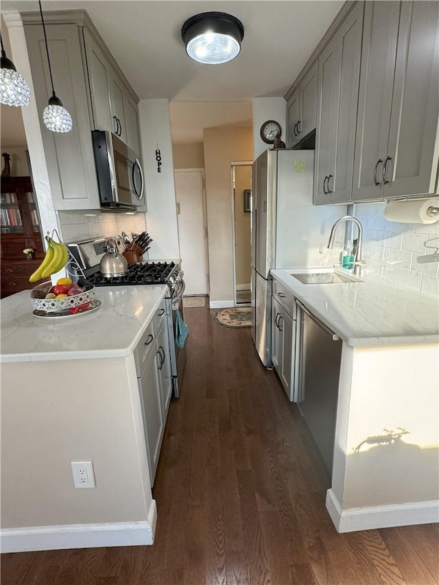 kitchen with tasteful backsplash, sink, dark hardwood / wood-style flooring, and appliances with stainless steel finishes