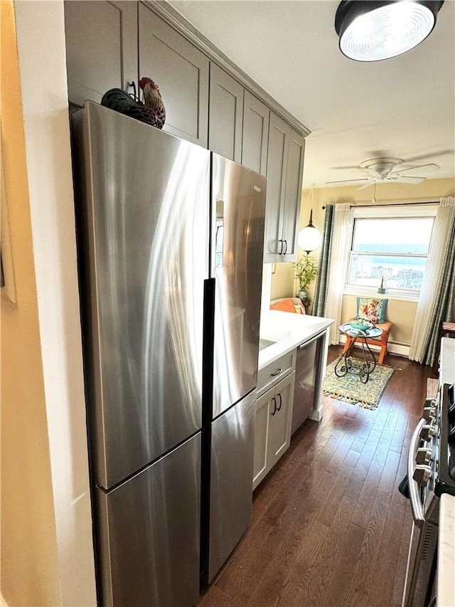 kitchen with gray cabinetry, ceiling fan, dark hardwood / wood-style flooring, and stainless steel appliances