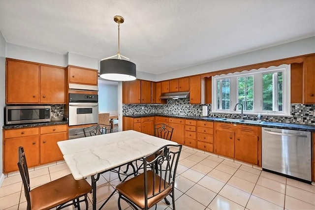 kitchen featuring sink, hanging light fixtures, stainless steel appliances, tasteful backsplash, and light tile patterned floors