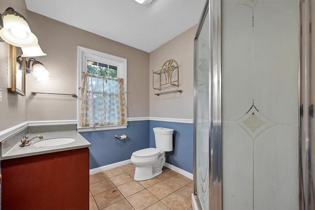 bathroom with toilet, vanity, tile patterned floors, and an enclosed shower