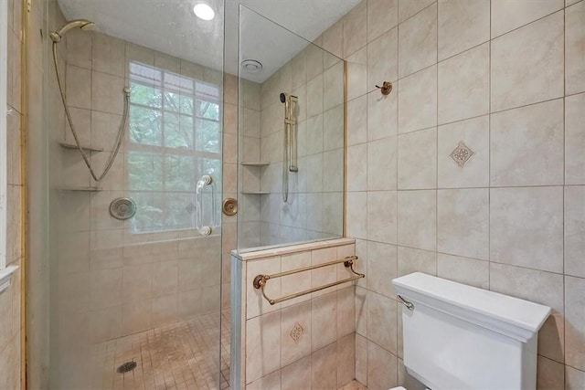 bathroom with tiled shower, tile walls, and toilet