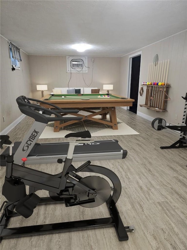 interior space with hardwood / wood-style flooring, a wall mounted air conditioner, and a textured ceiling