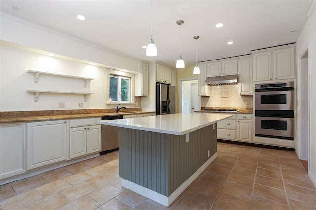 kitchen featuring white cabinets, decorative light fixtures, a center island, and stainless steel appliances