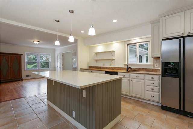 kitchen with hanging light fixtures, stainless steel fridge with ice dispenser, light wood-type flooring, a kitchen island, and white cabinetry