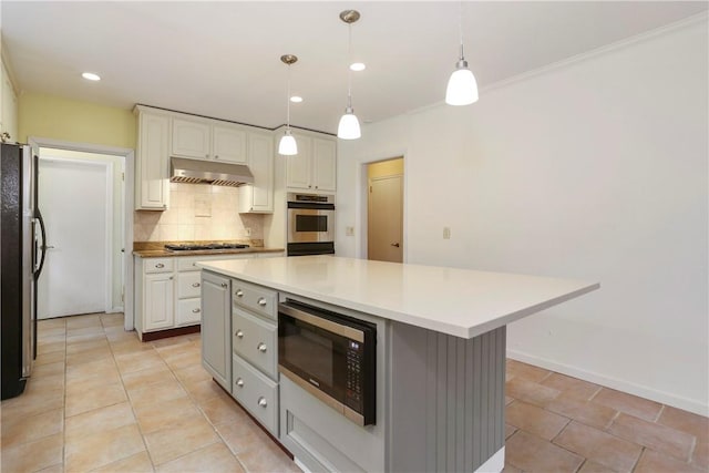 kitchen with pendant lighting, white cabinets, stainless steel appliances, and a kitchen island