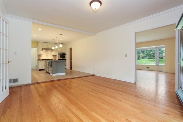 unfurnished living room with light hardwood / wood-style floors, crown molding, and french doors