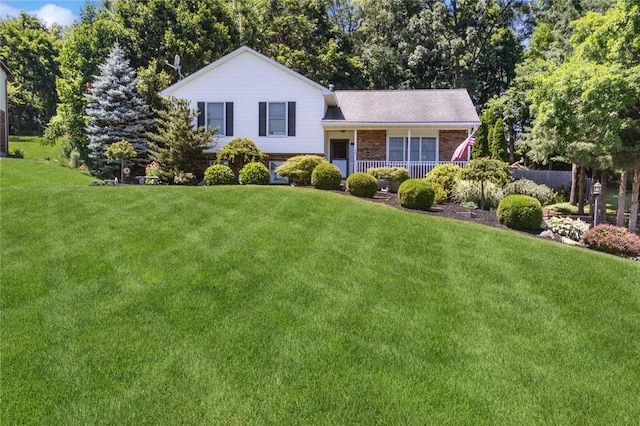 tri-level home featuring covered porch and a front yard