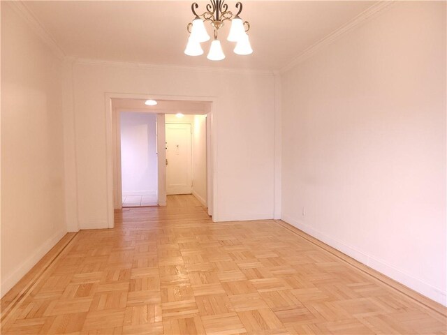 empty room with a notable chandelier, crown molding, and light parquet flooring