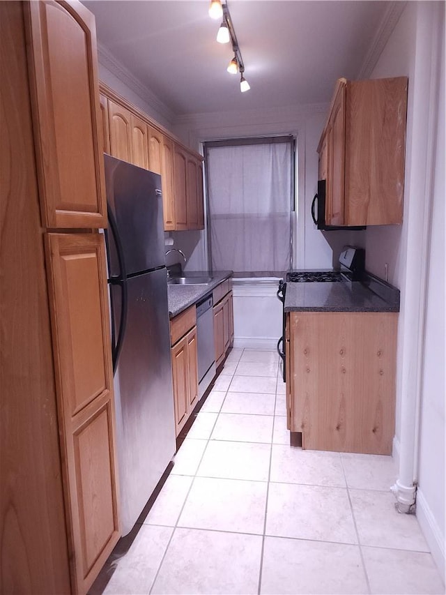 kitchen with crown molding, light tile patterned floors, stainless steel appliances, and dark stone counters