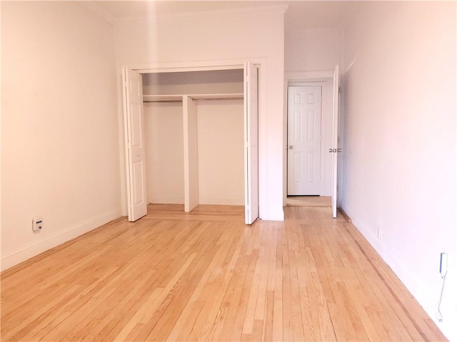 unfurnished bedroom with a closet and light wood-type flooring