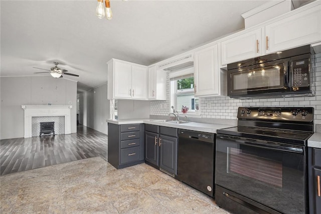 kitchen featuring decorative backsplash, a brick fireplace, sink, black appliances, and white cabinets