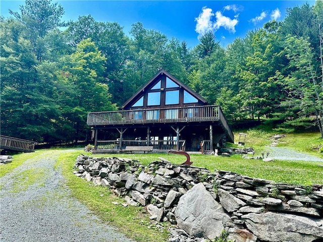 back of house featuring a wooden deck and a lawn