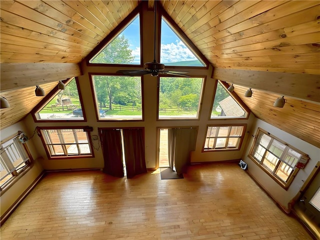 unfurnished living room with ceiling fan, wood ceiling, high vaulted ceiling, and a healthy amount of sunlight