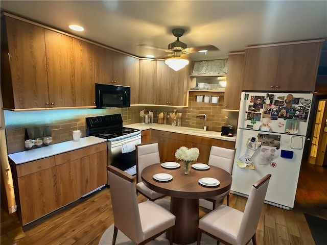 kitchen featuring range with electric cooktop, sink, hardwood / wood-style flooring, white fridge, and ceiling fan