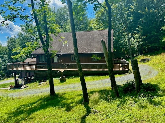 exterior space featuring a wooden deck and a lawn