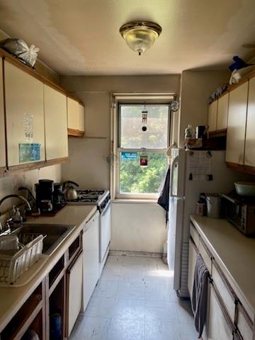 kitchen with white cabinetry, sink, and white dishwasher