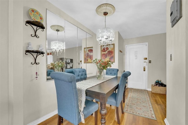 dining space with hardwood / wood-style flooring and a notable chandelier