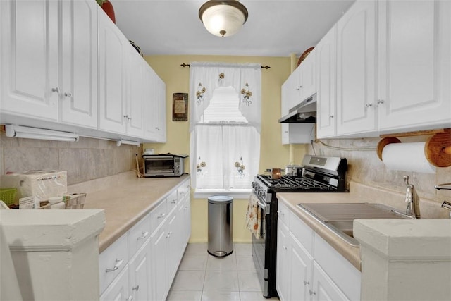 kitchen with tasteful backsplash, white cabinetry, light tile patterned floors, and stainless steel range with gas stovetop