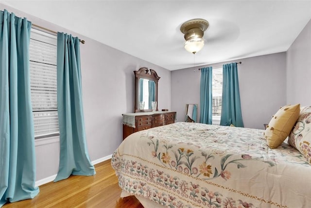 bedroom with light hardwood / wood-style flooring, multiple windows, and ceiling fan