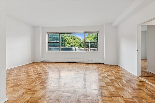 empty room featuring light parquet flooring and a baseboard heating unit