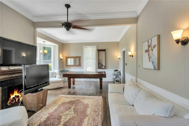 living room with wood-type flooring, crown molding, and ceiling fan