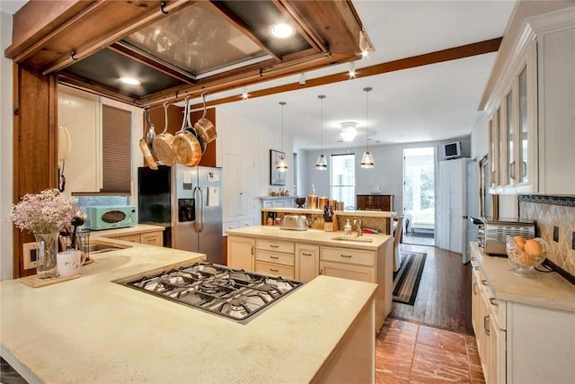 kitchen with sink, tasteful backsplash, hanging light fixtures, stainless steel appliances, and a large island