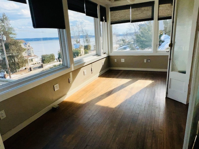 unfurnished sunroom with a water view and plenty of natural light