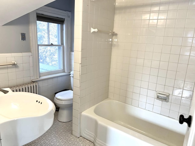 full bathroom featuring tile patterned floors, toilet, tile walls, radiator heating unit, and tiled shower / bath combo