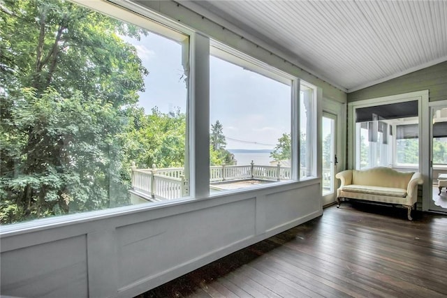 unfurnished sunroom featuring vaulted ceiling and a water view