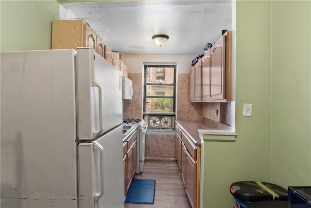 kitchen featuring light wood-type flooring and white appliances