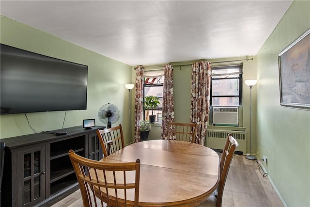 dining area with cooling unit and light hardwood / wood-style floors