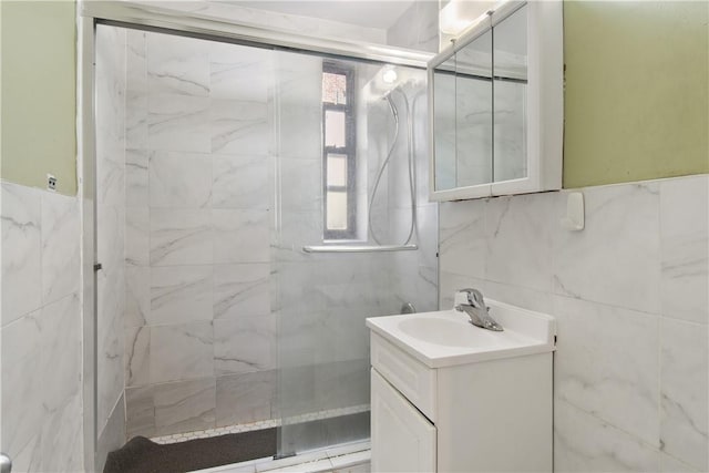 bathroom with vanity, tile walls, and walk in shower