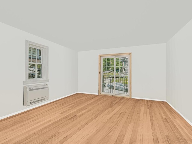 spare room with heating unit and light hardwood / wood-style floors